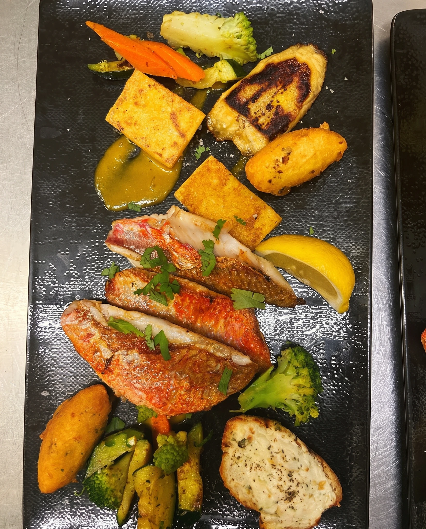 Filets de rougets barbets rôtis sur peau, polenta grillée, banane plantain poêlée, accras de morue et légumes confits