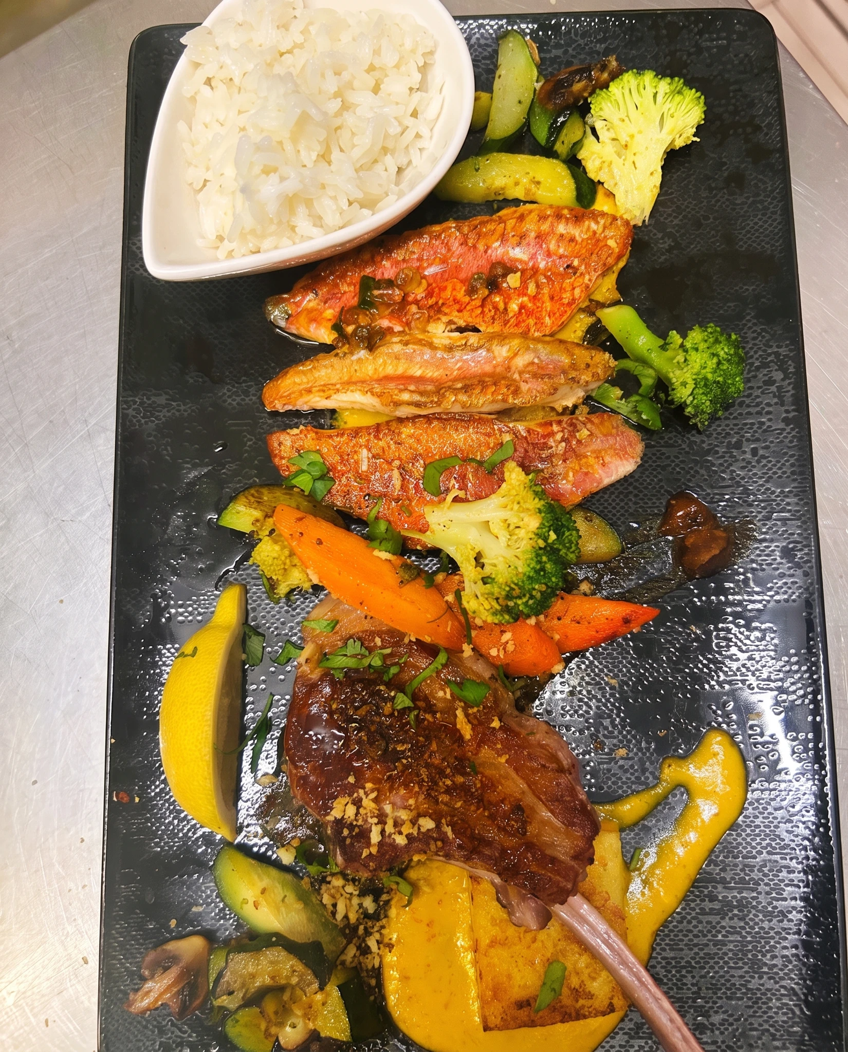 Filets de rougets rôtis et côtelette grillée, riz blanc, polenta, légumes poêlés et sauce maison